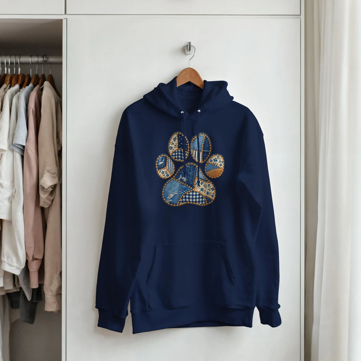 Navy Faux Patchwork Dog Women's Pullover Hoodie hanging in a wardrobe