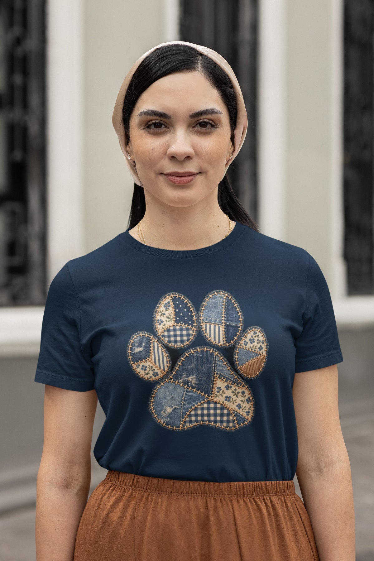 Smiling woman in a headscarf wearing the Navy Faux Patchwork Club Women's T-shirt with a rust skirt