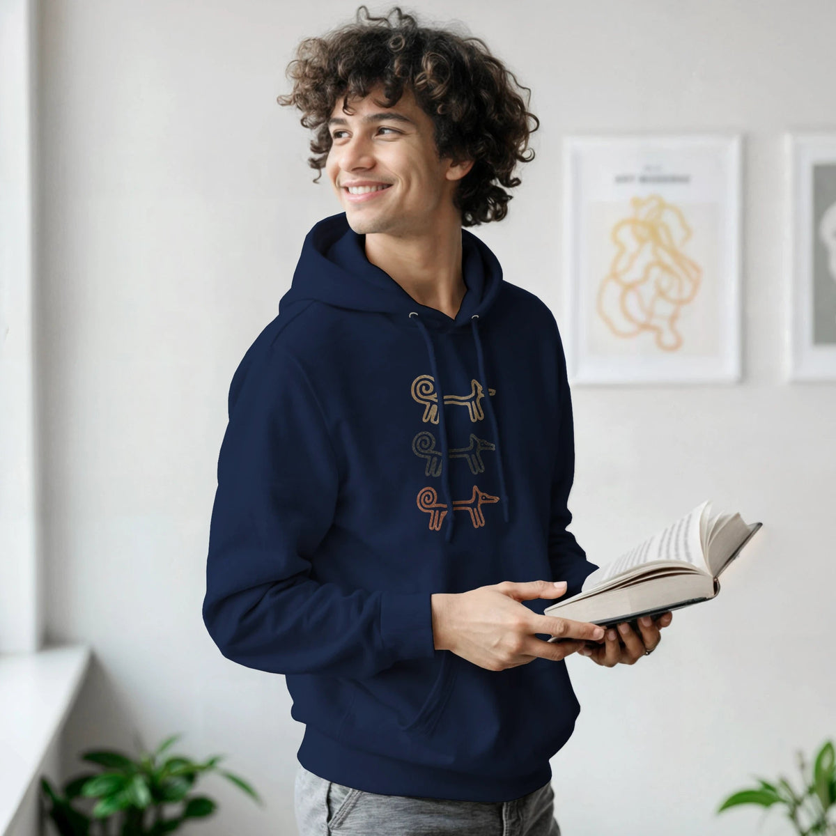 Man reading a book in the navy Dog Totem men's hoodie