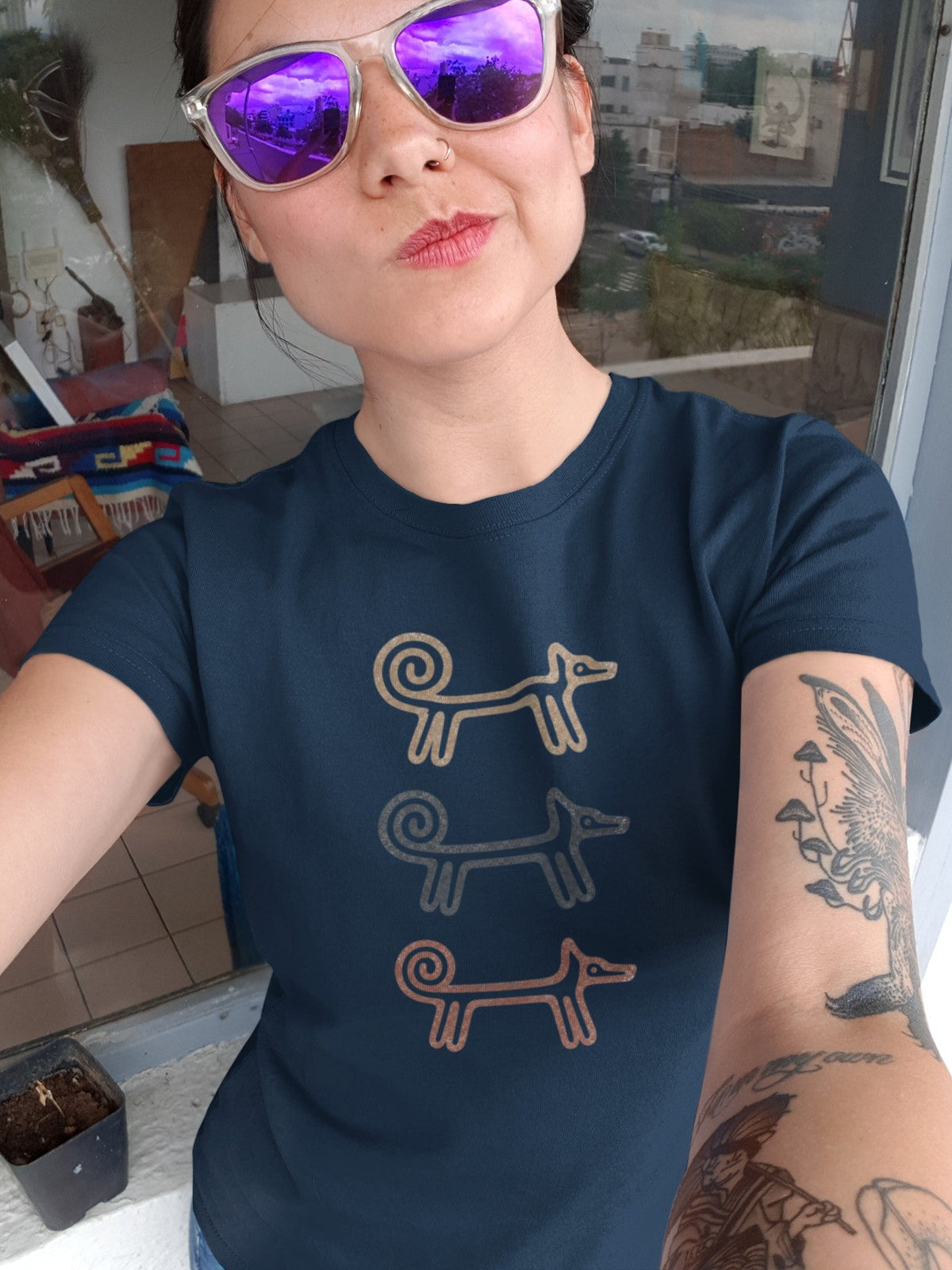 Woman in purple sunglasses taking a selfie in the navy Dog Totem T-shirt
