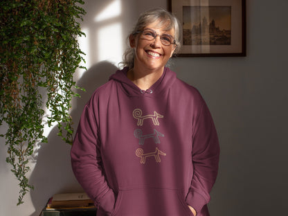 Smiling woman indoors wearing the maroon Dog Totem women's hoodie