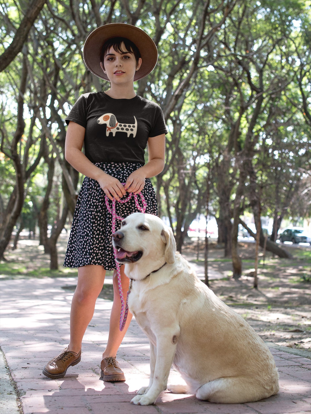 Woman in the black Kawaii Dog T-shirt standing in a park with a Golden Retriever